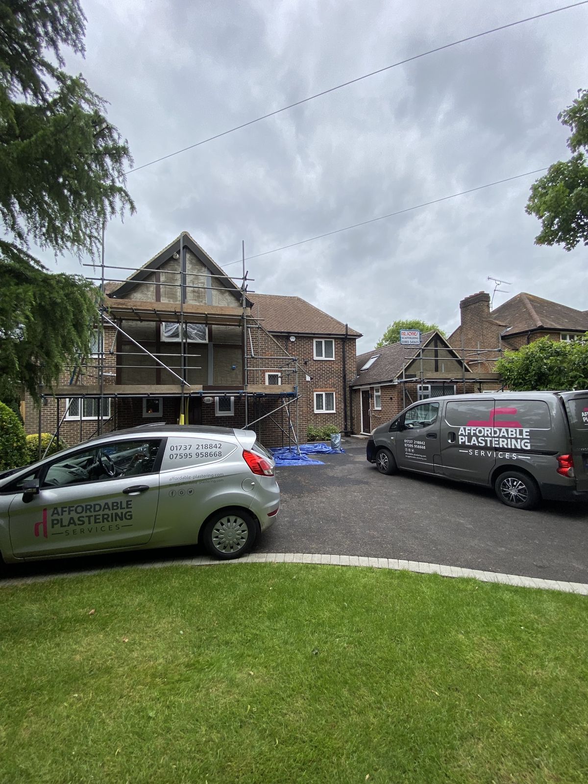 Two Affordable Plastering Services vans parked on a client’s driveway