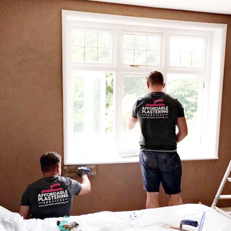Two Affordable Plastering Services plasterers skimming a bedroom wall